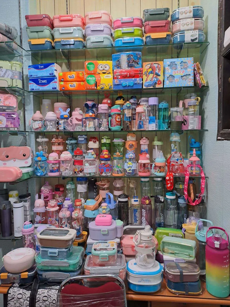 Rak botol minum, kotak makan, dan tisu di toko BunBo